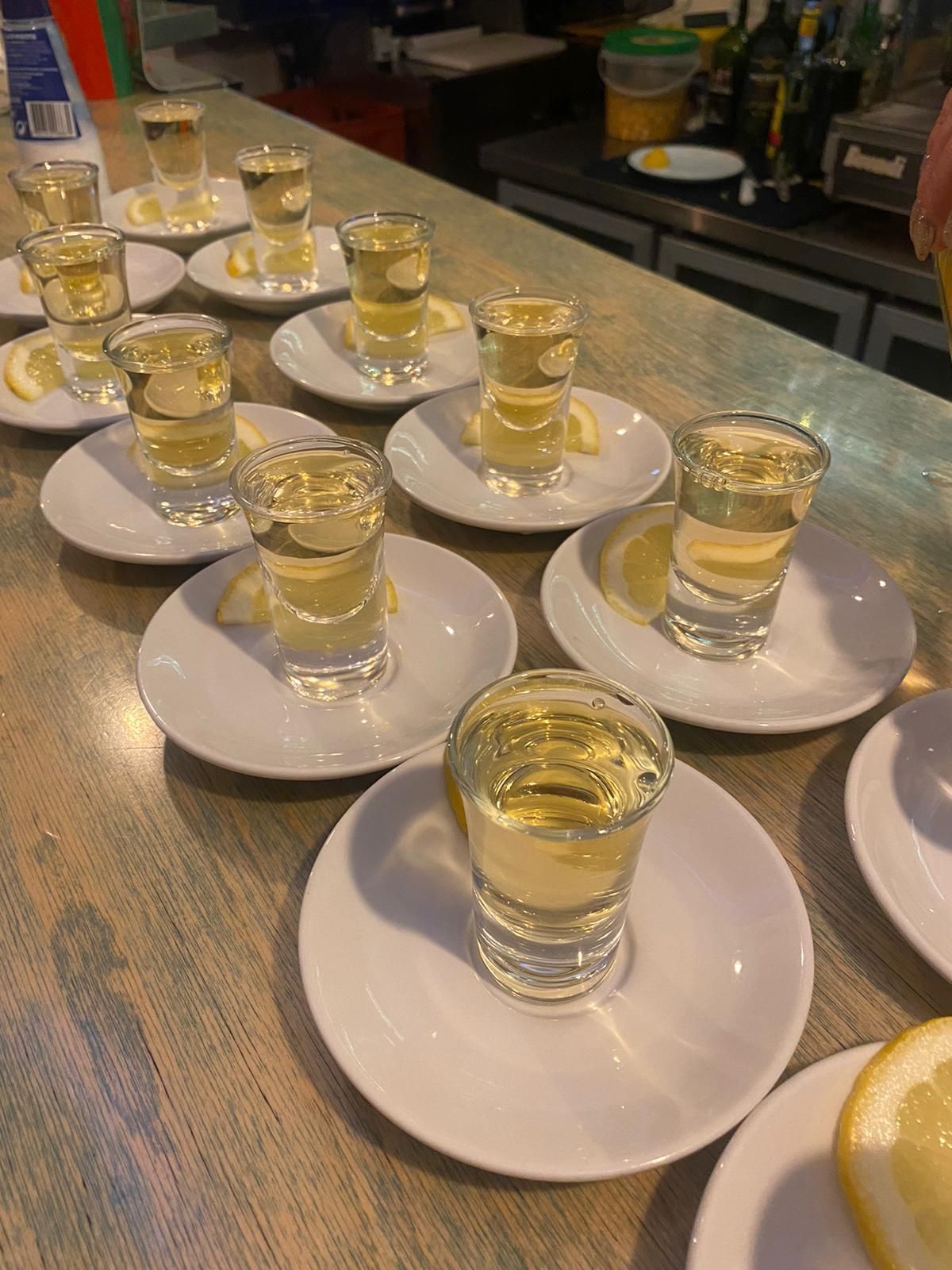 A row of shot glasses sitting on plates on a table.