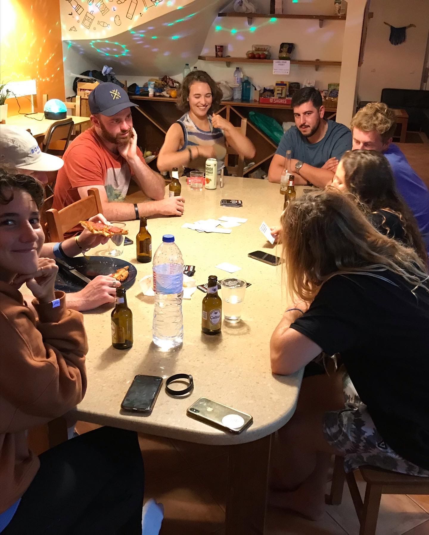 A group of people are sitting around a table eating and drinking