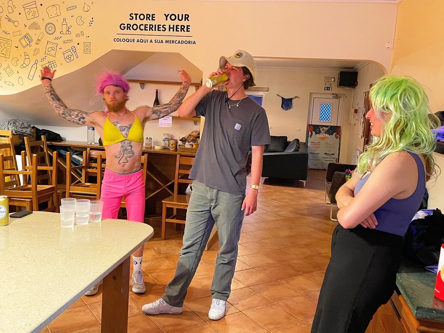 A group of people are standing in a room with a sign that says store your groceries here