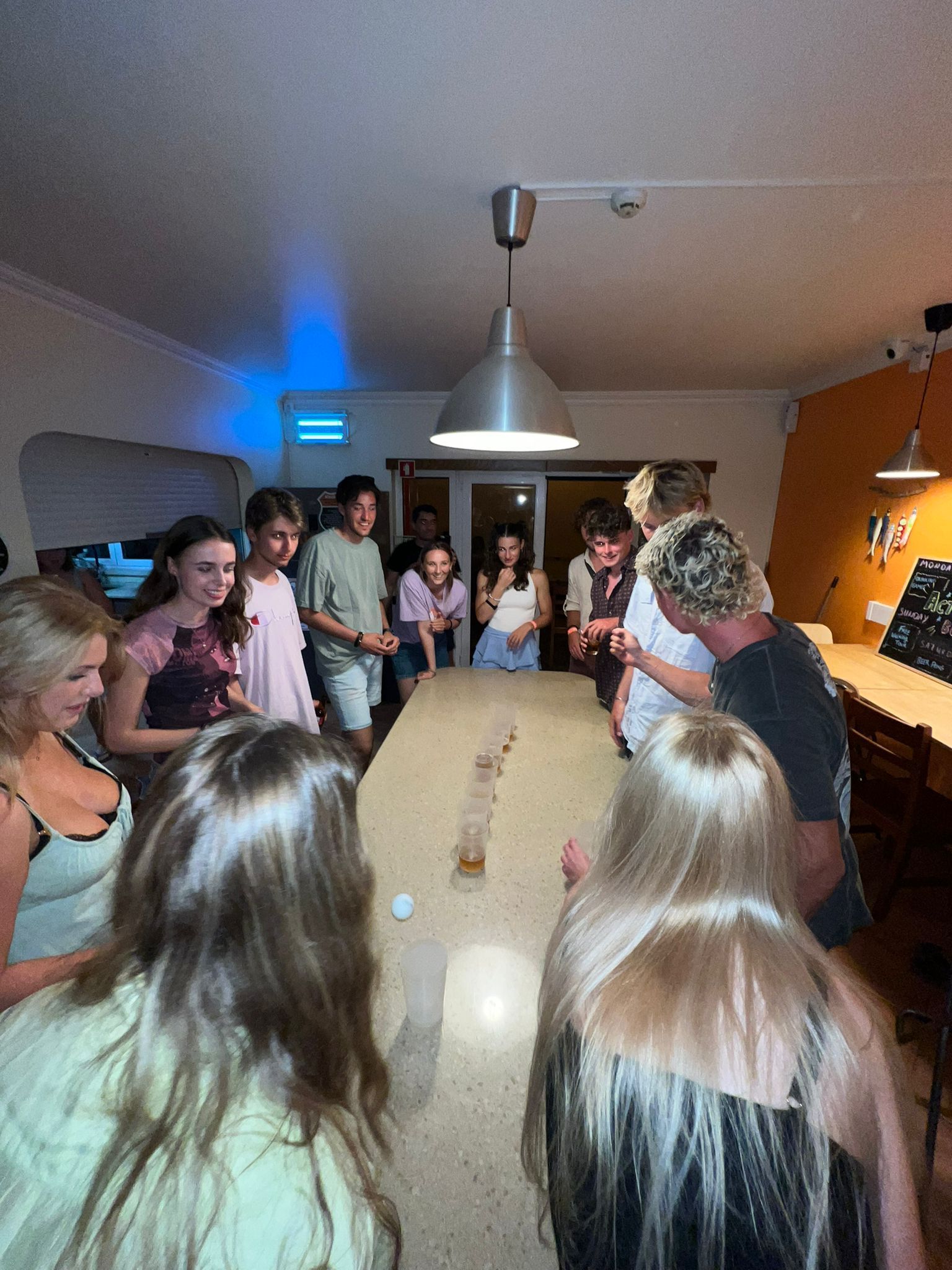 A group of people are standing around a long table.