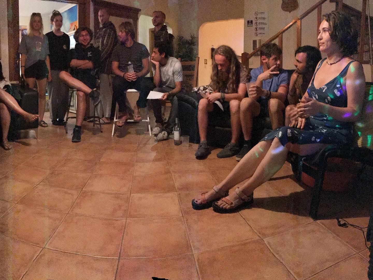 A group of people are sitting in a circle in a living room.