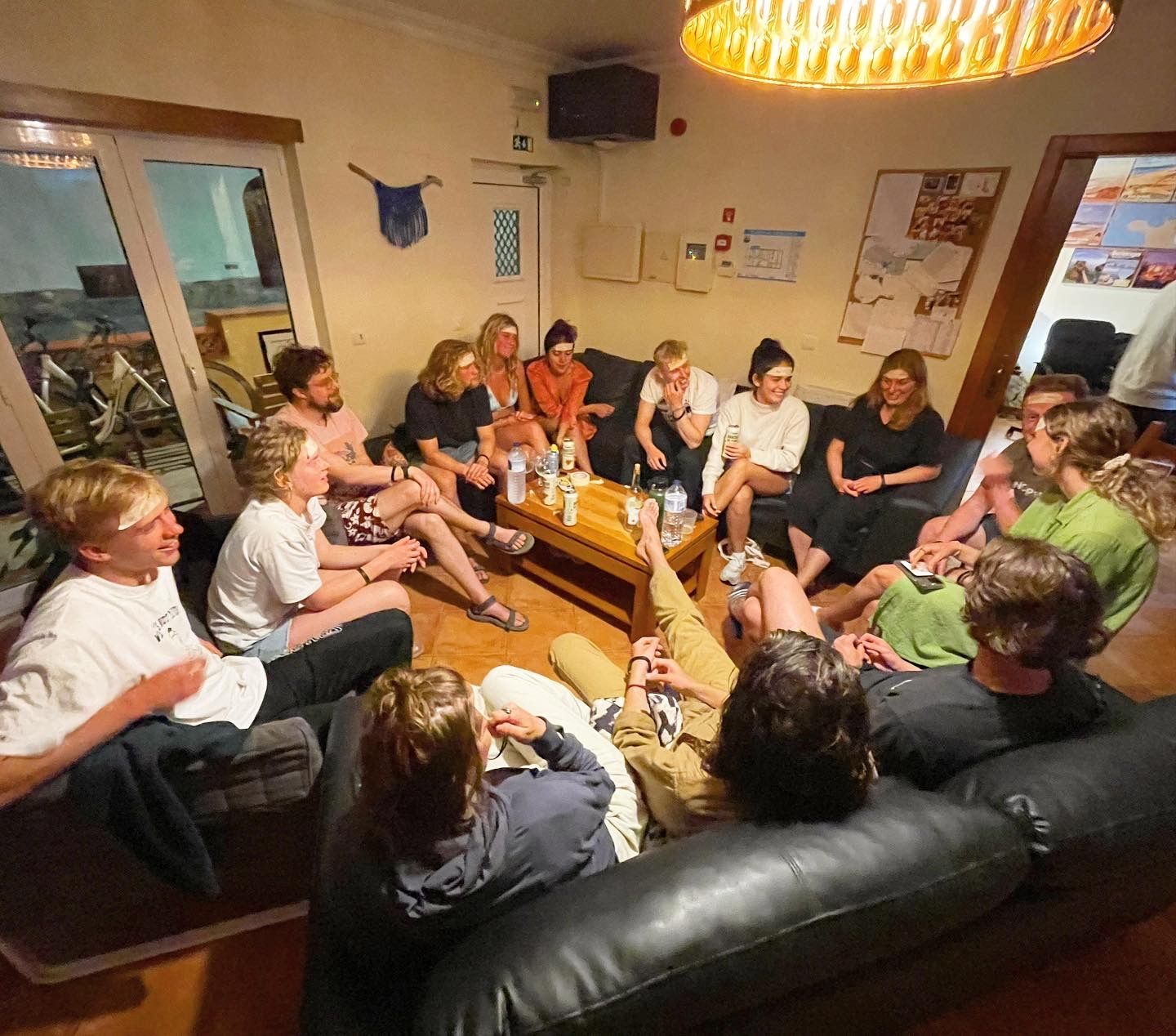 A group of people are sitting around a table in a living room