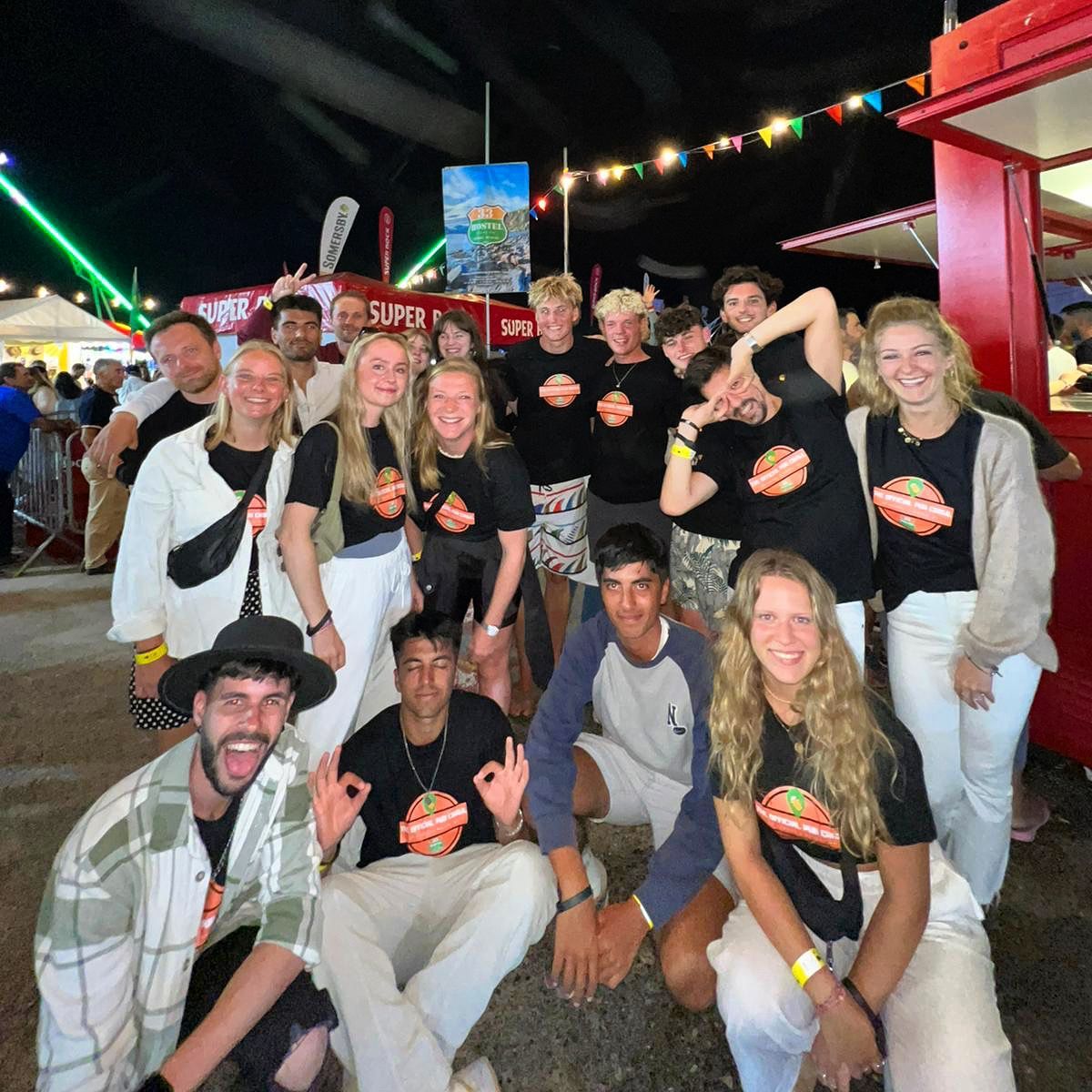 A group of people posing for a picture in front of a sign that says super