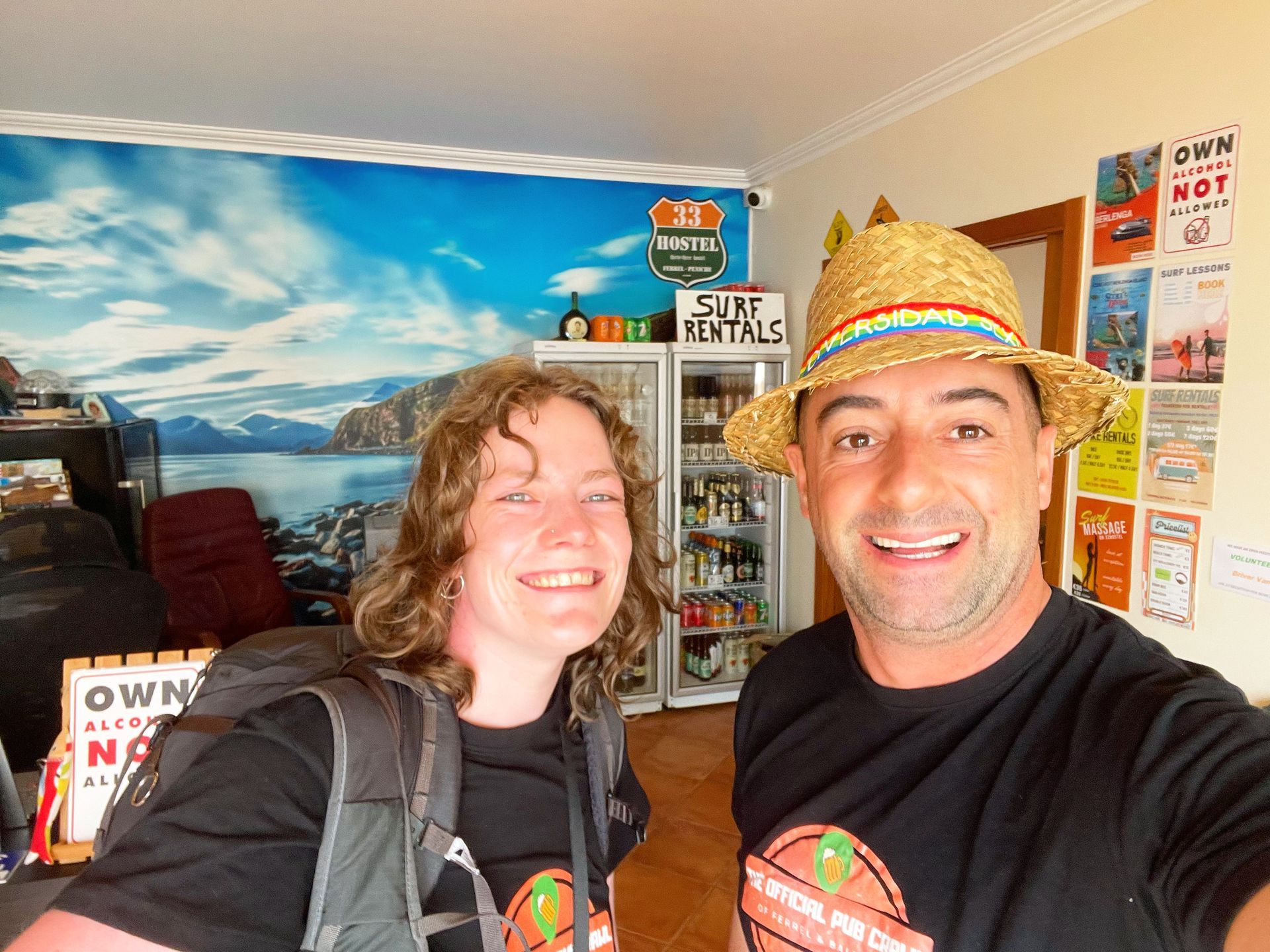 A man and a woman are posing for a picture in front of a sign that says surf rentals