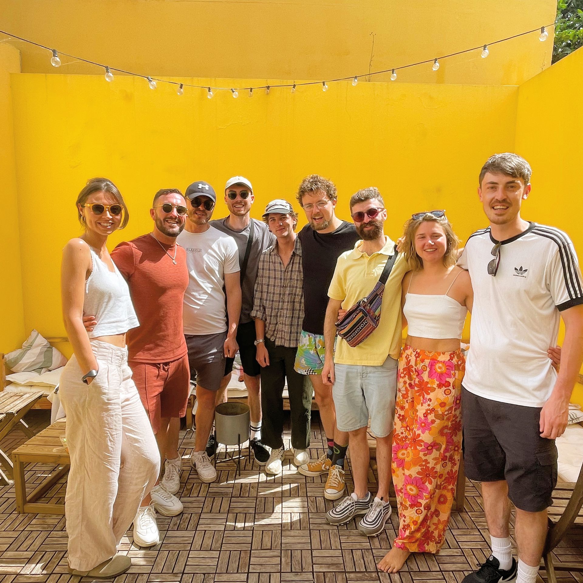 A group of people posing for a picture in front of a yellow wall
