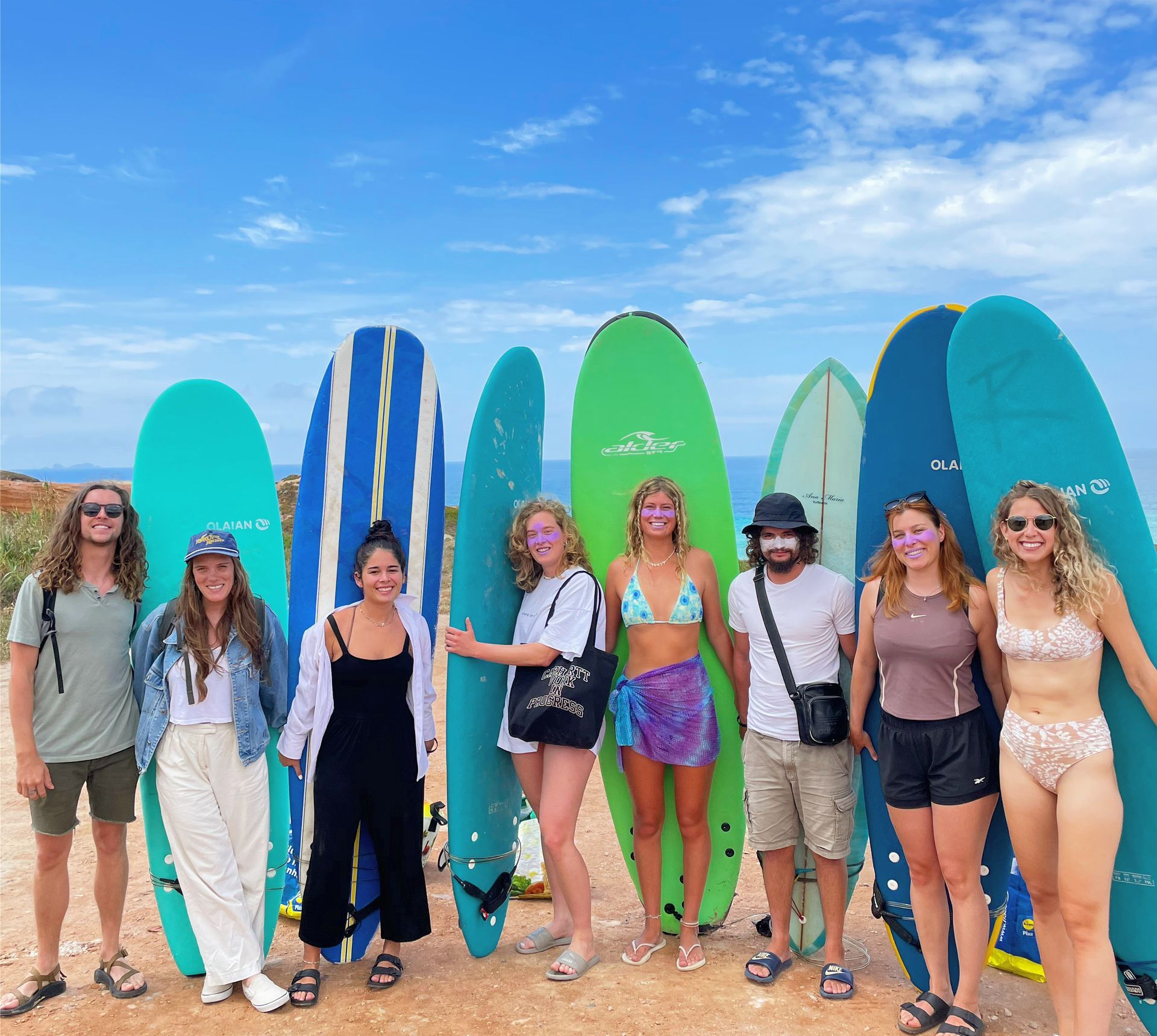 A group of people standing next to surfboards on a beach