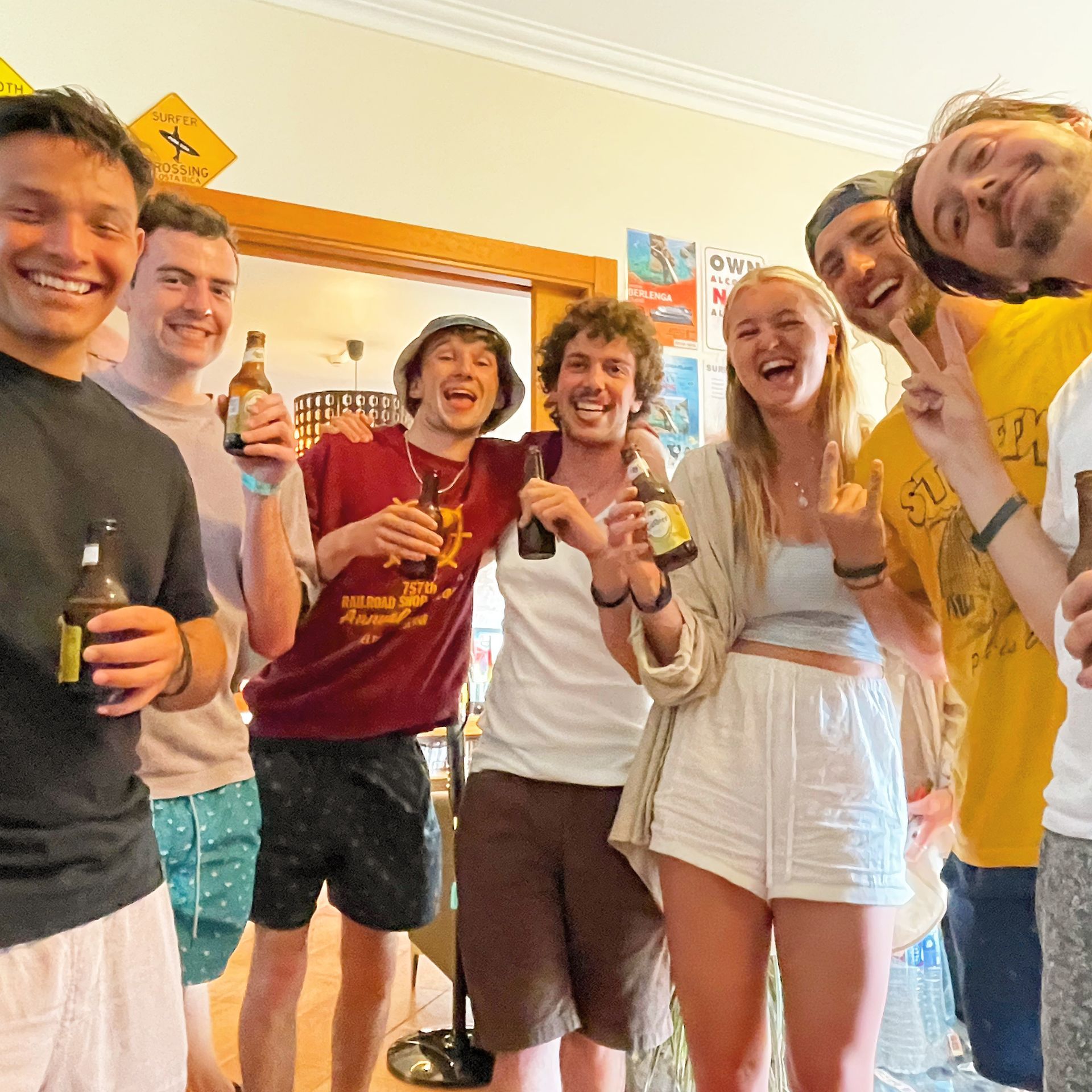 A group of people are posing for a picture while holding bottles of beer