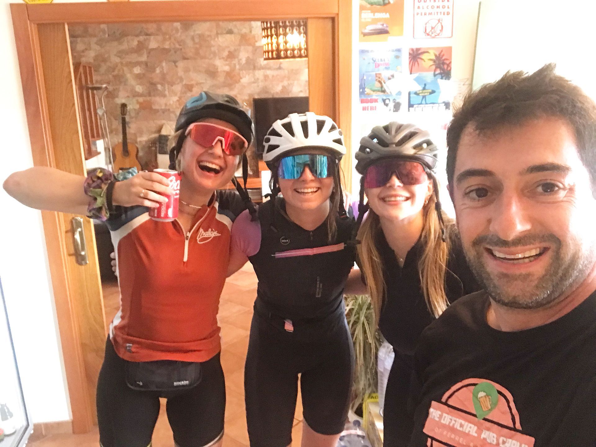A man and three women are posing for a picture while wearing helmets and sunglasses.