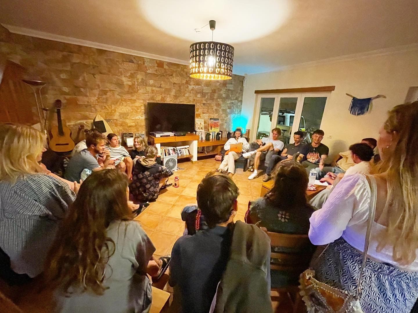 A group of people are sitting in a circle in a living room.