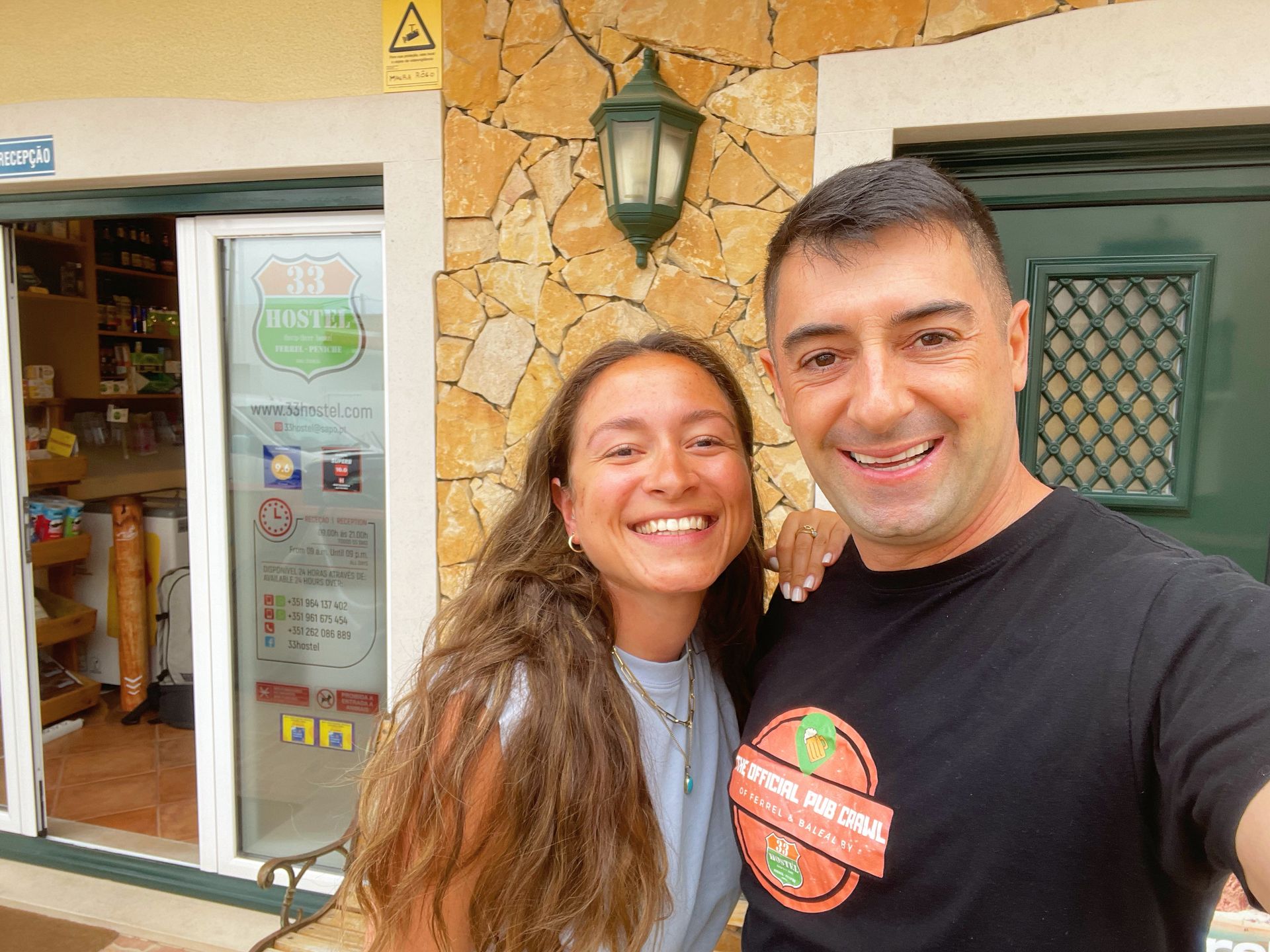 A man and a woman are posing for a picture in front of a building.