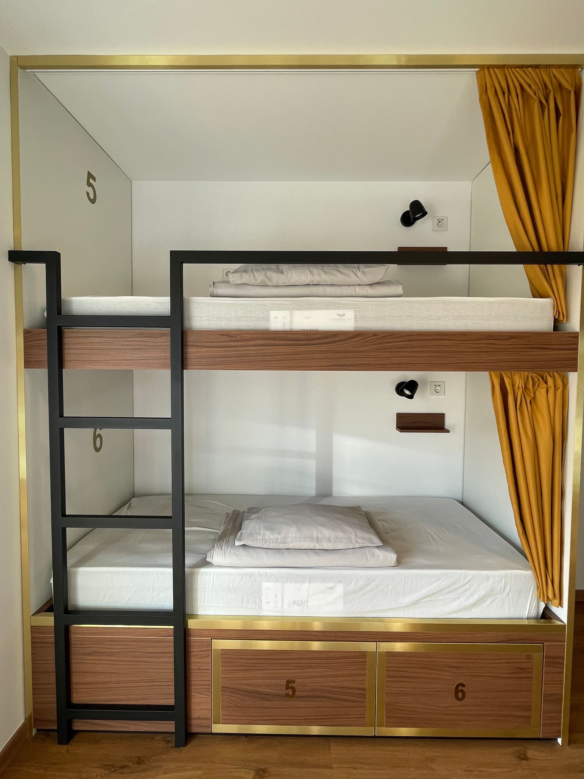 A bunk bed with a ladder and drawers underneath it