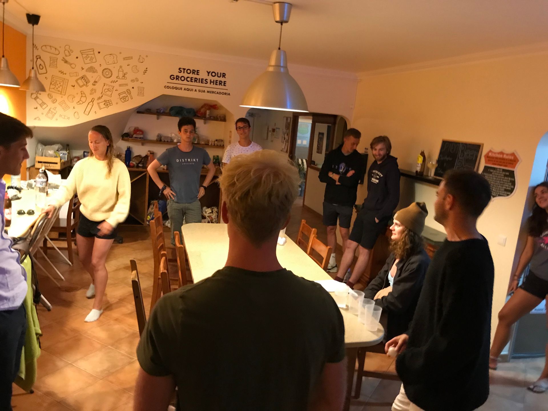 A group of people are standing around a long table in a room.