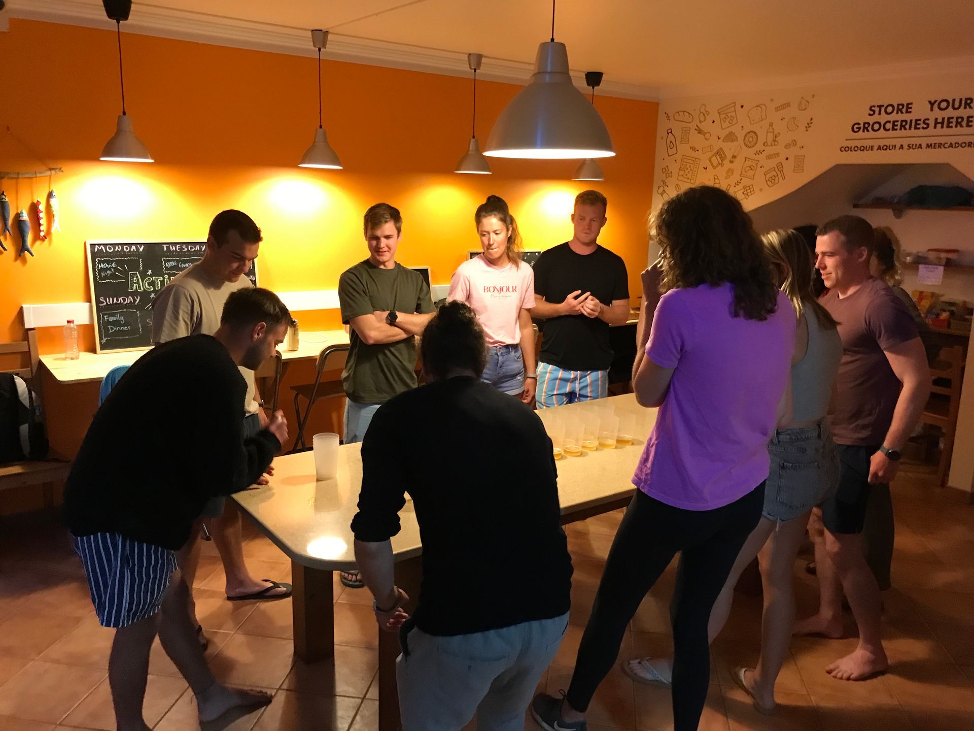 A group of people are standing around a table in a room.