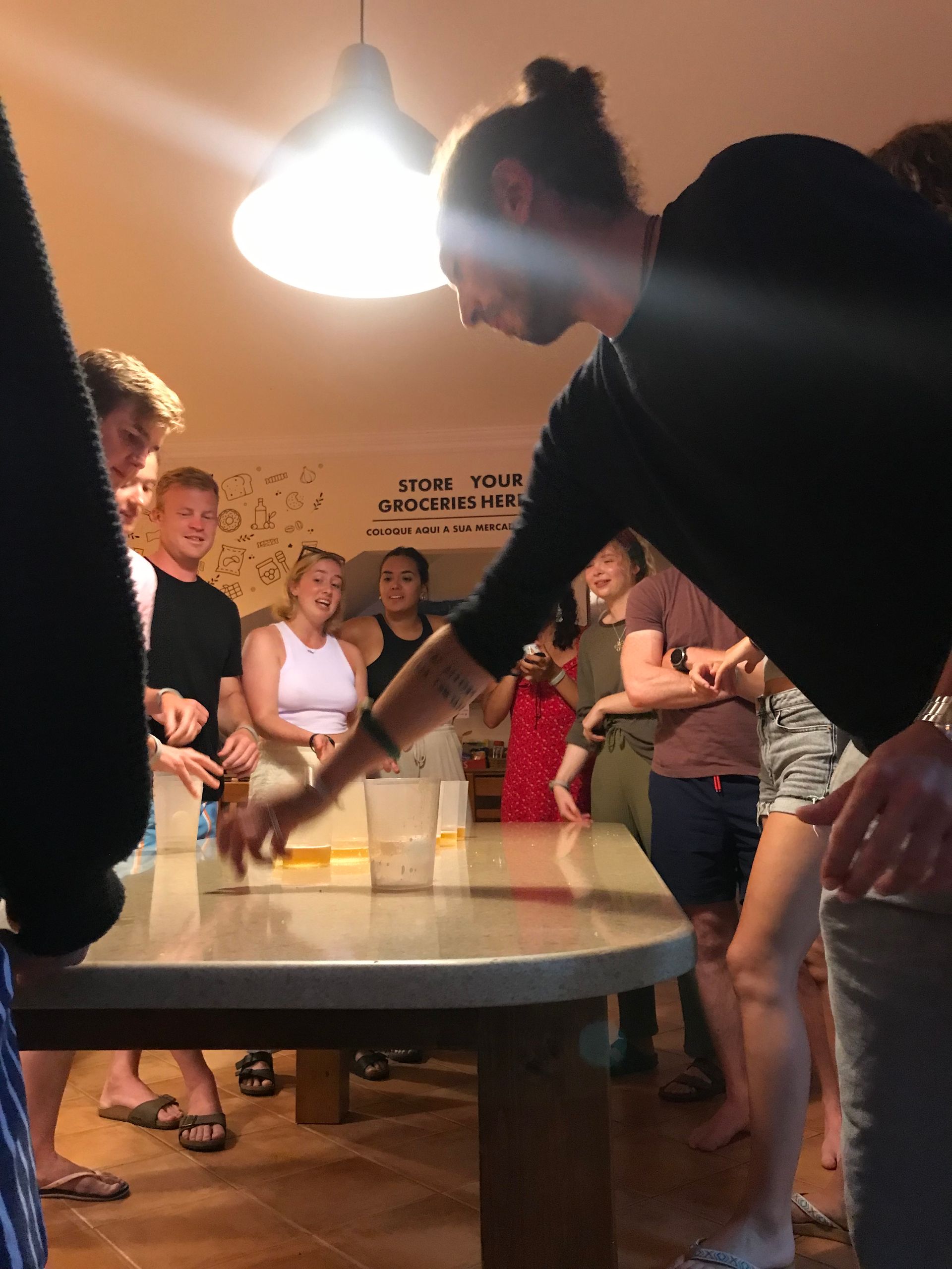 A group of people are playing a game of beer pong