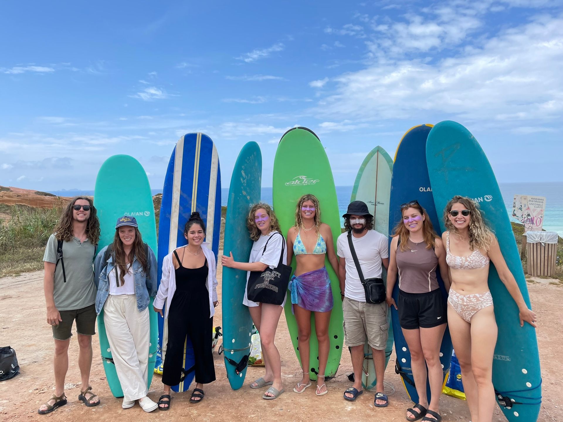 A group of people standing next to surfboards on a beach.