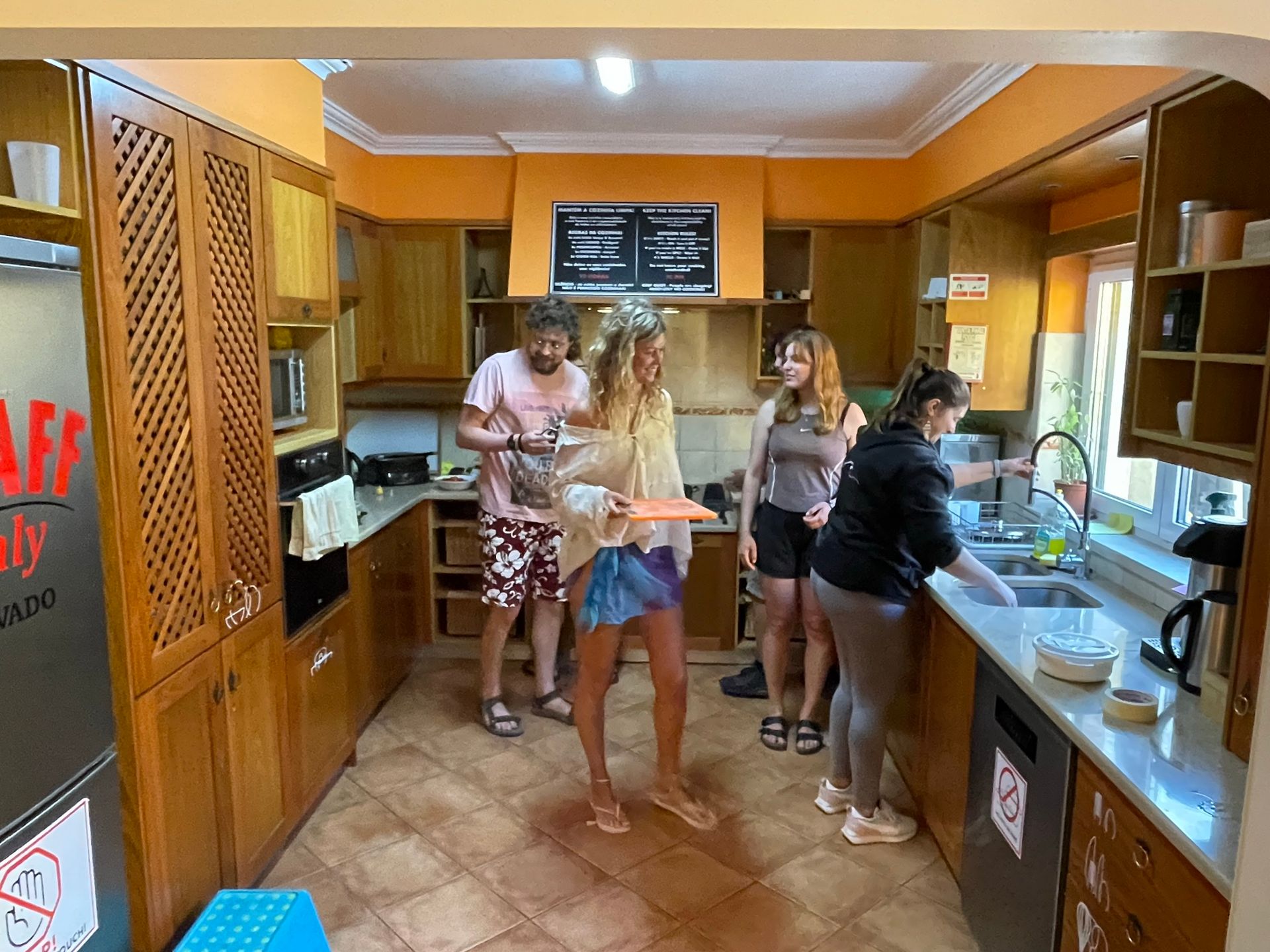 A group of people are standing in a kitchen preparing food.