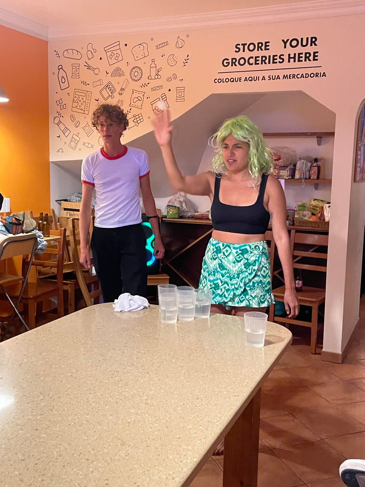 A man and a woman are standing next to a table in a restaurant.
