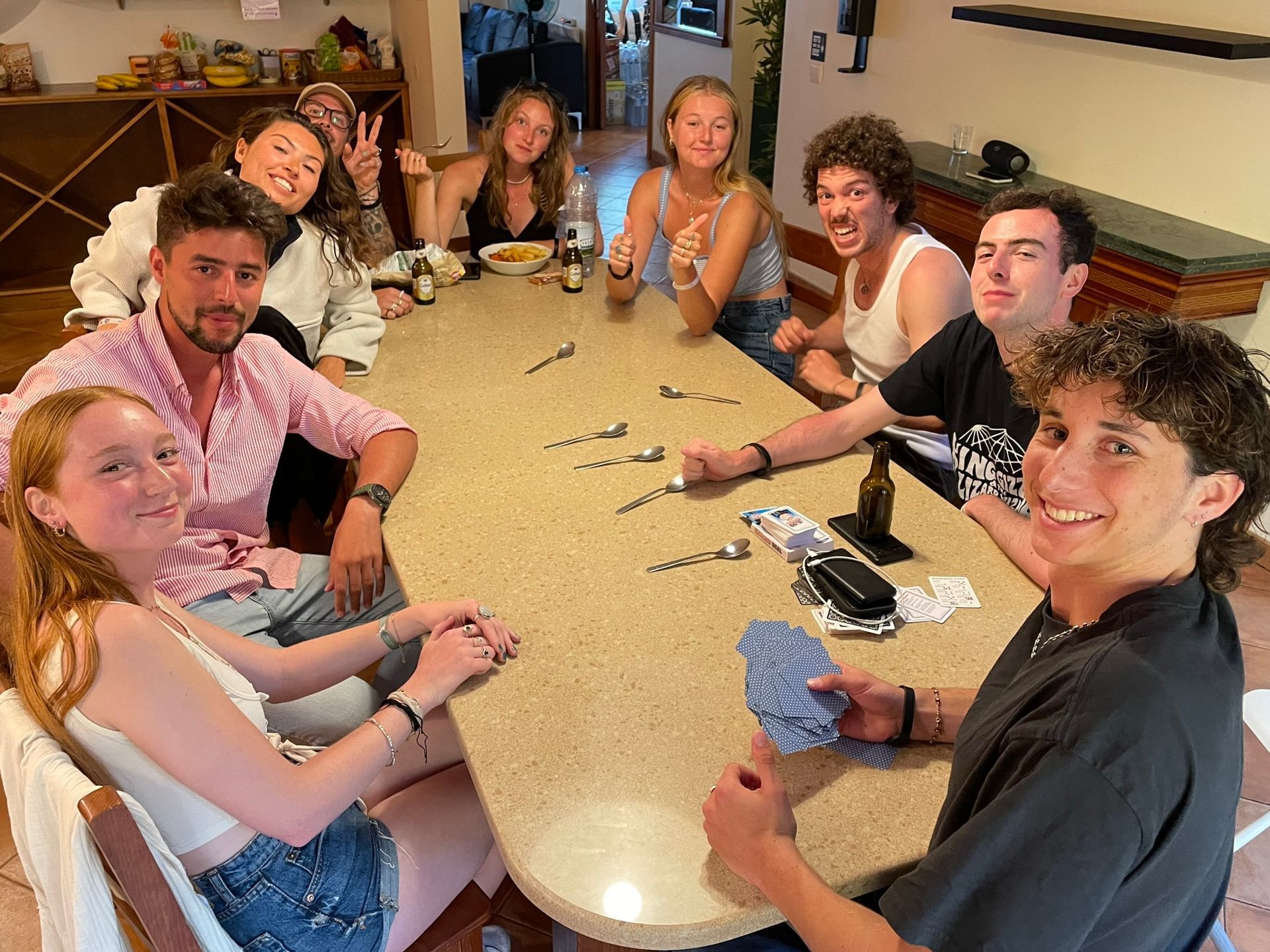 A group of people are sitting around a table playing cards.