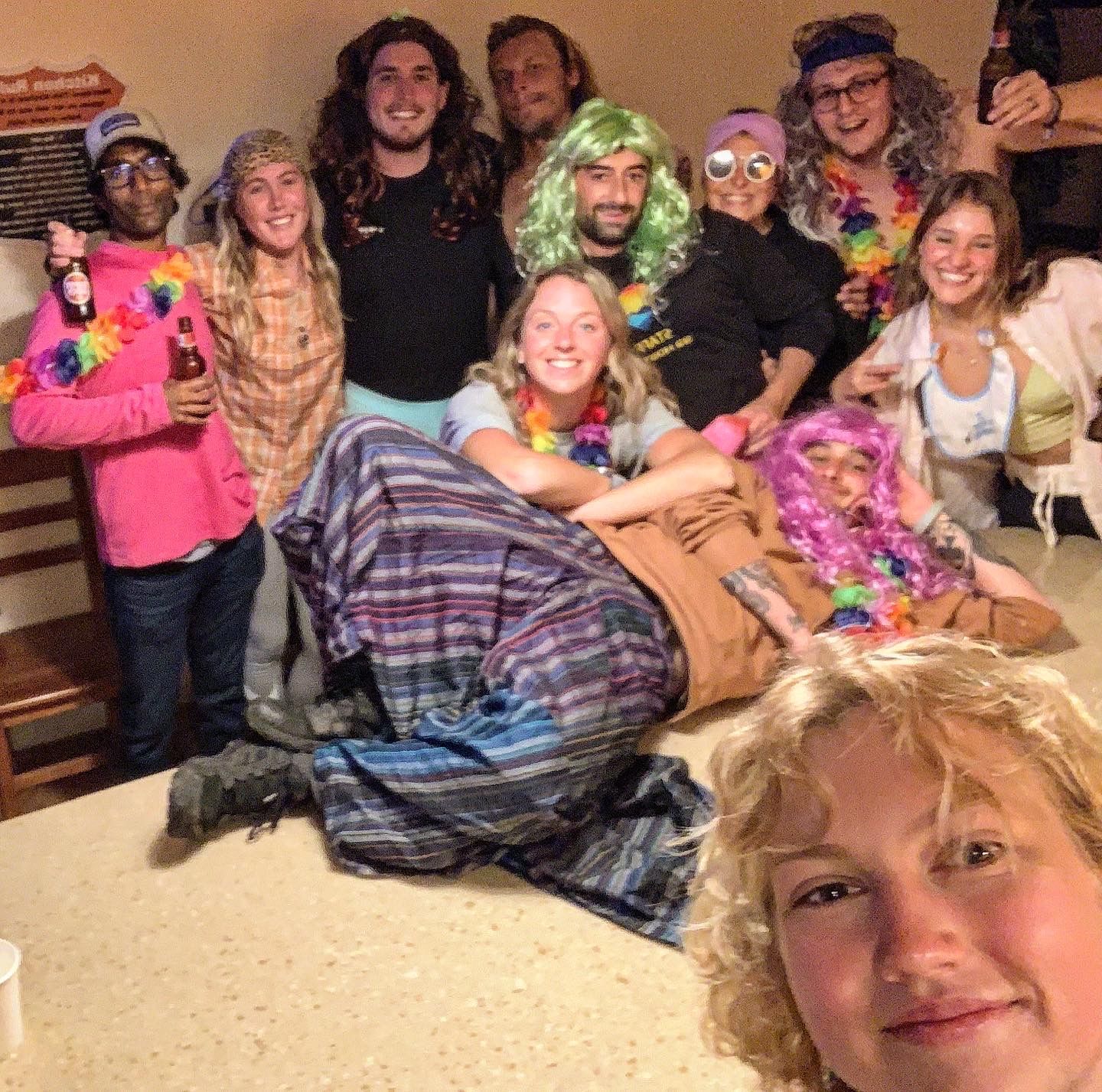 A group of people are posing for a picture and one of them is wearing a wig