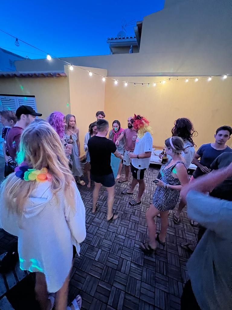 A group of people are dancing on a patio at a party.