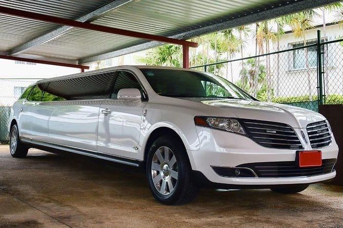 White Lincoln limousine parked under a shelter.