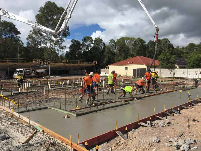 Construction workers pouring concrete on a foundation, using a pump truck — Bampak In Gympie, QLD