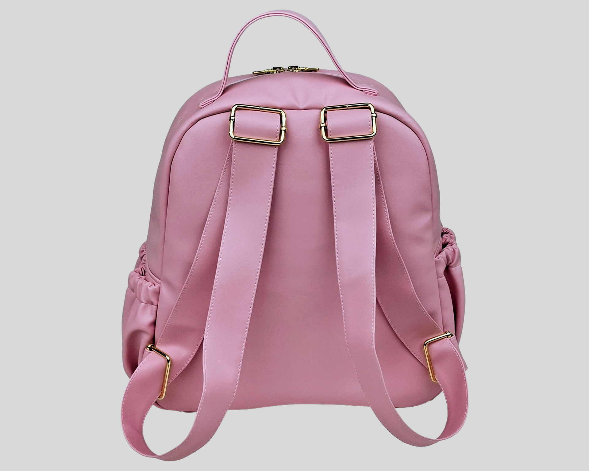 MOCHILA PELE SINTÉTICA LISA COR ROSA COM BOLSOS EXTERIORES À FRENTE E DOS LADOS, FECHO DE CORRER, ALÇAS TRASEIRAS AJUSTÁVEIS, ACESSÓRIOS DOURADOS.