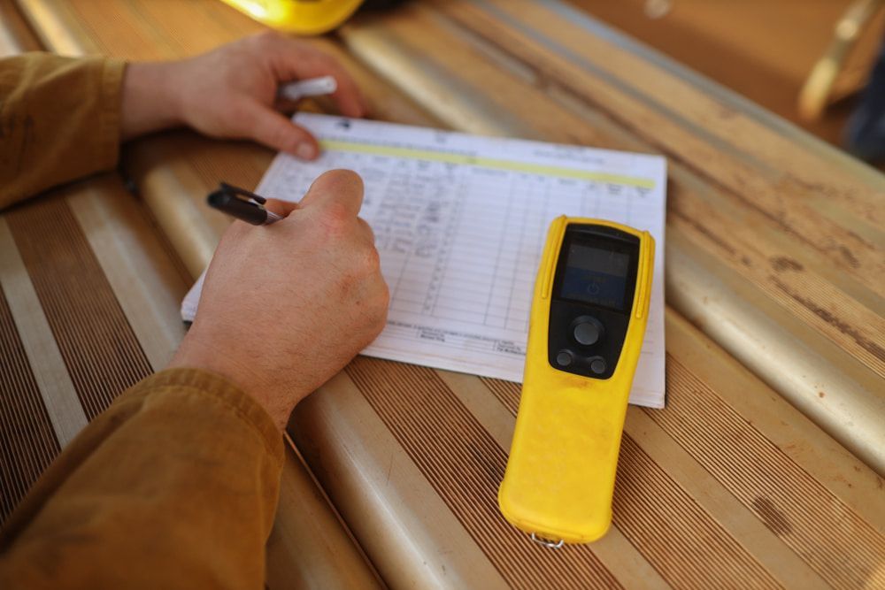 A Person Is Writing On A Piece Of Paper Next To A Yellow Device — Canary North Pty Ltd In Annandale, QLD