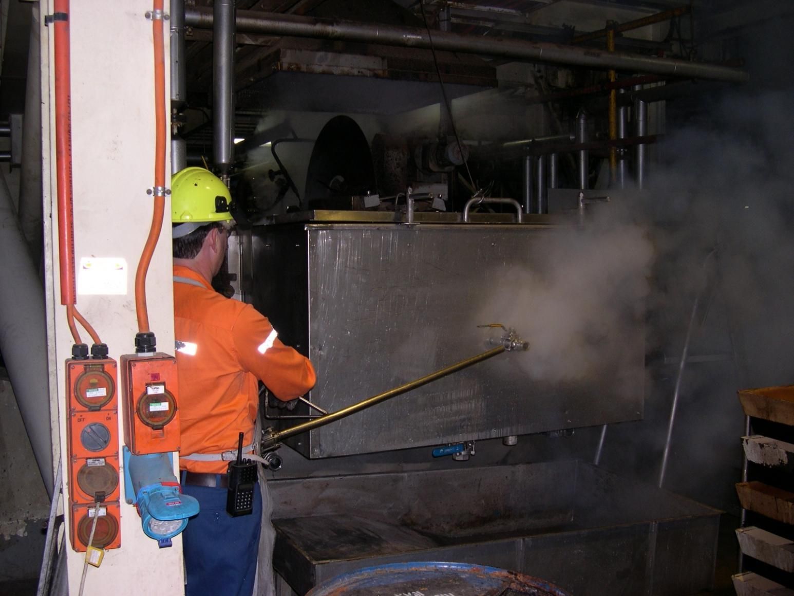 A Man Wearing A Yellow Hard Hat Is Spraying Something With A Hose — Canary North Pty Ltd In Annandale, QLD