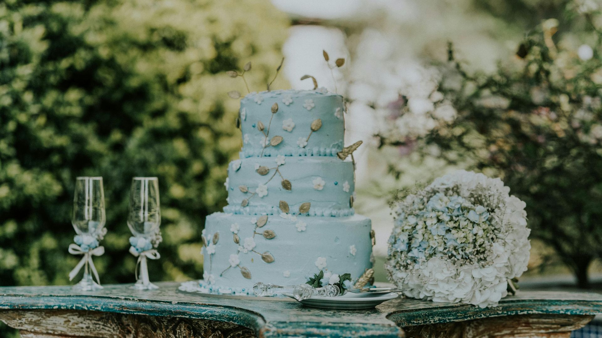 three tier blue wedding cake with dainty floral design