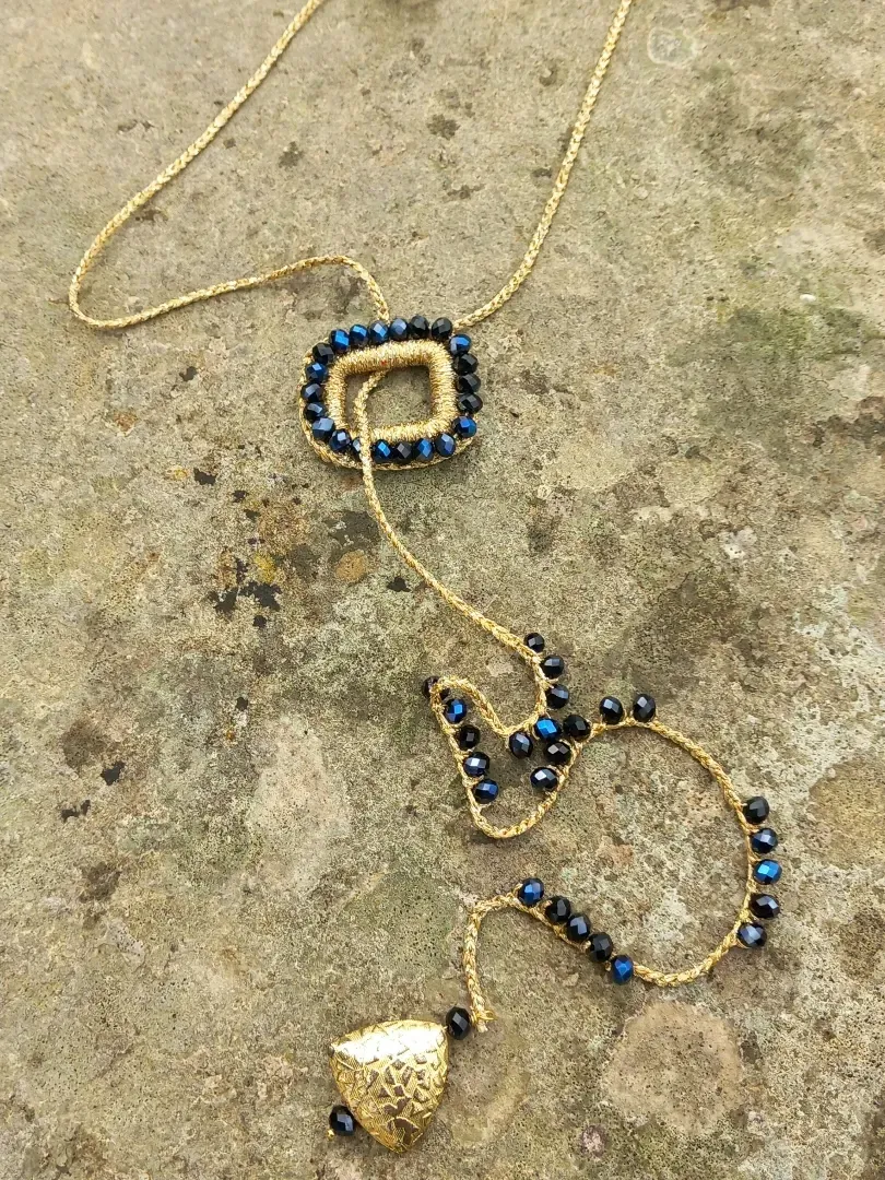 Collana di perline con perline blu e oro su una superficie di cemento