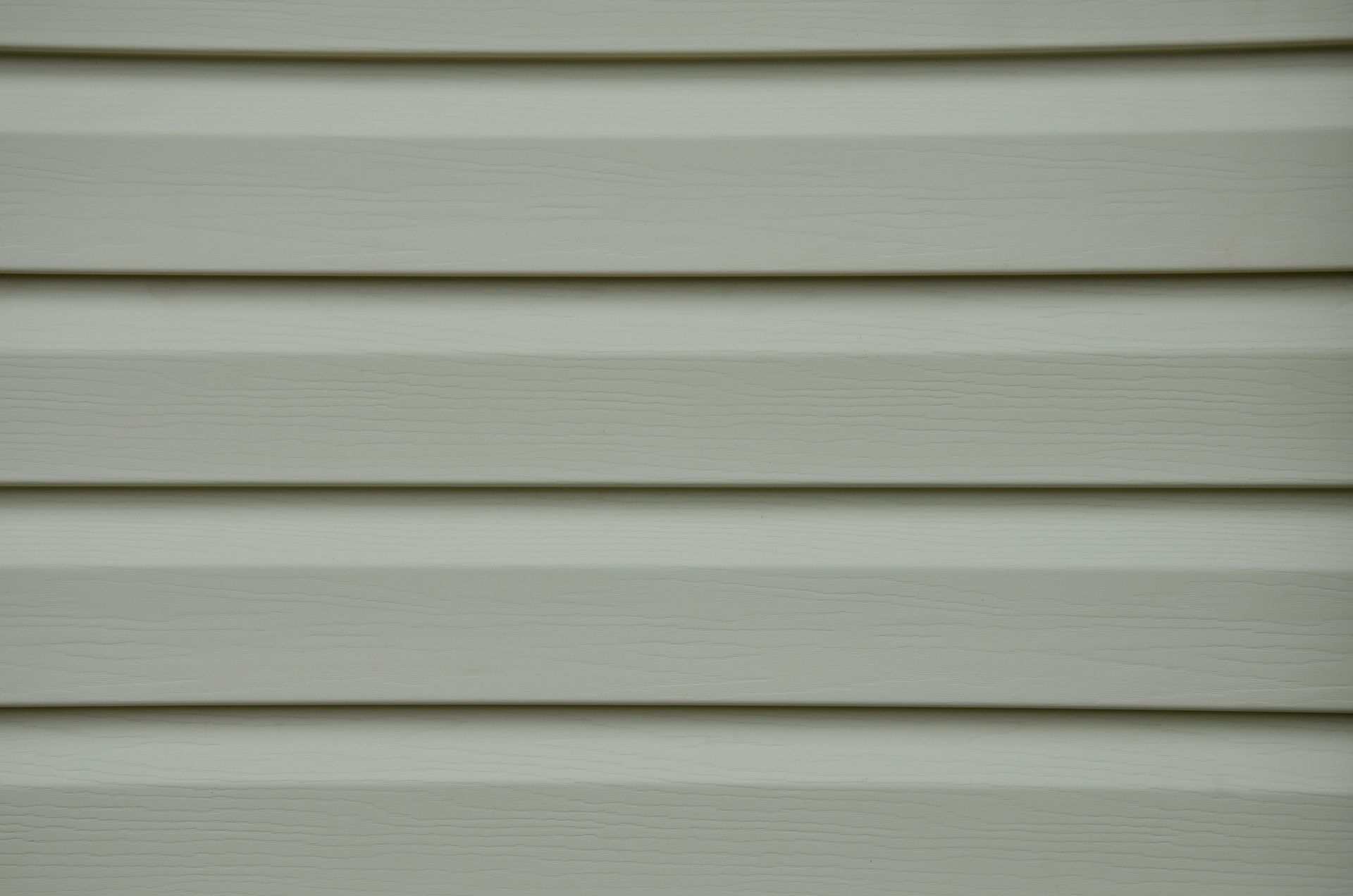 A close up of a white vinyl siding on a house.