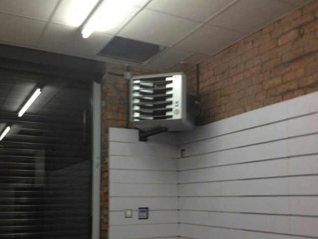 a room with a heater hanging from the ceiling