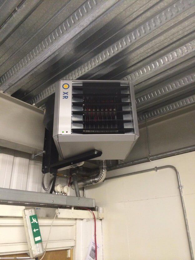 A heater is hanging from the ceiling of a building.