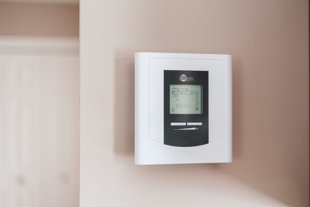 a thermostat is hanging on a wall in a room .