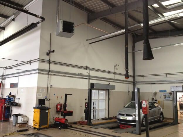 a silver car is on a lift in a garage