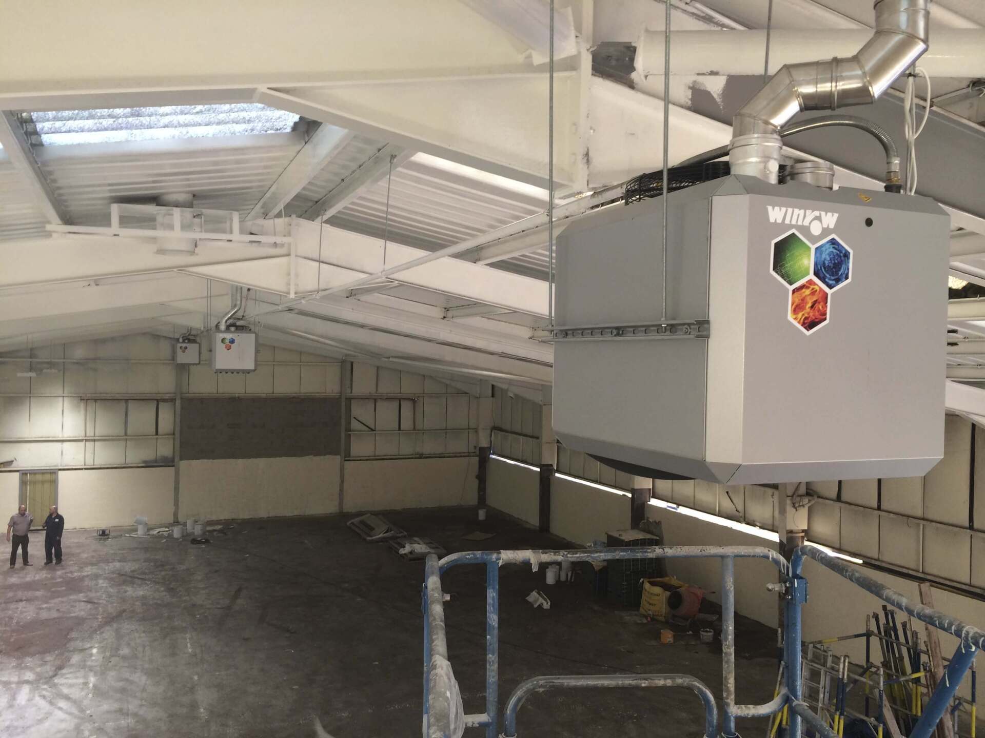 Gray HVAC unit suspended from the ceiling of an indoor sports facility.