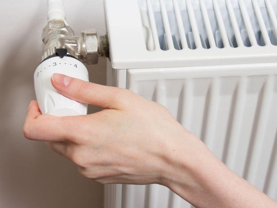 a person is adjusting a radiator with their finger .