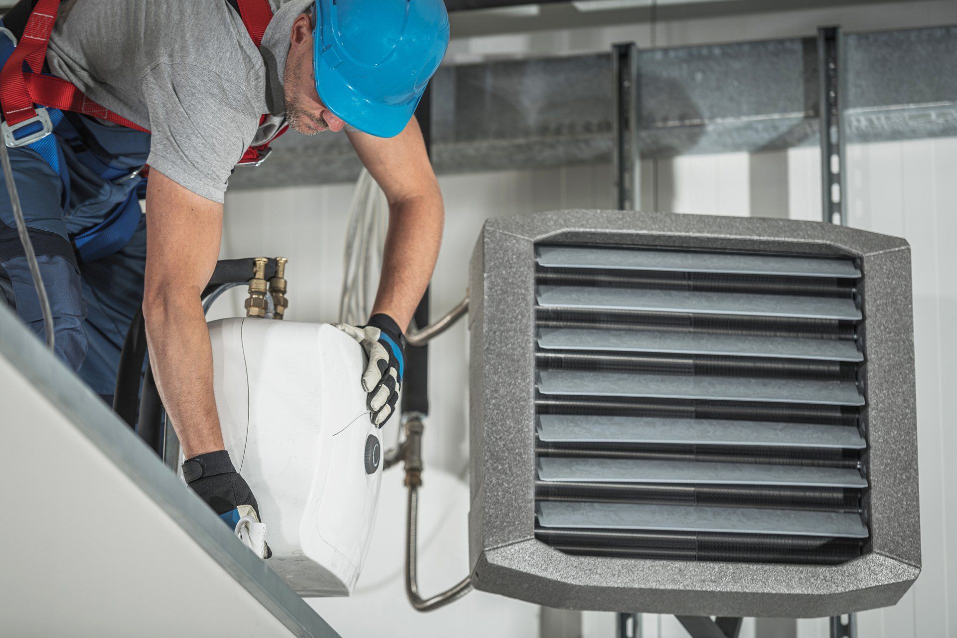 A man is working on a heater in a building.