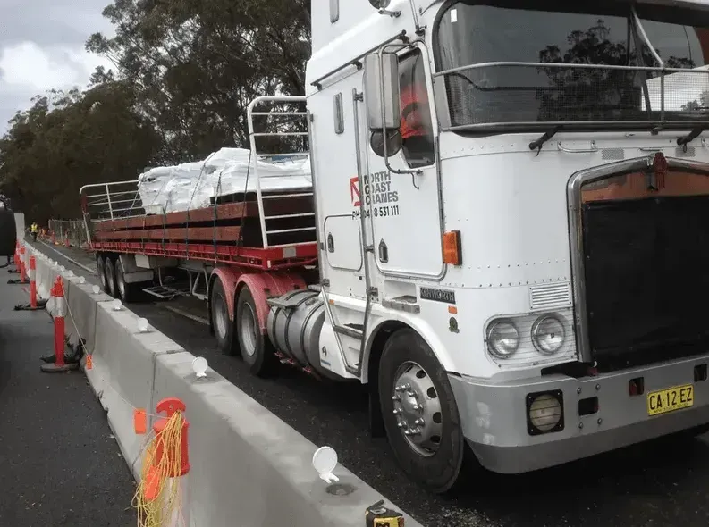 A White Semi Truck Is Driving Down a Highway — North Coast Cranes In Bellingen, NSW