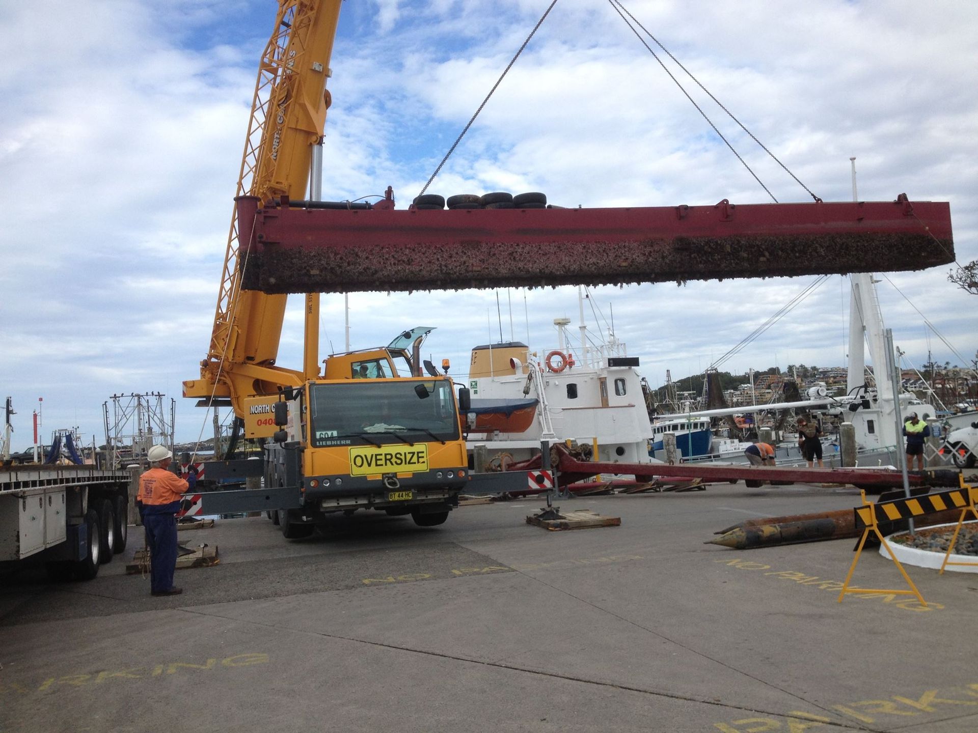 A Crane Is Lifting A Large Piece Of Metal In A Harbor — North Coast Cranes In Bellingen, NSW