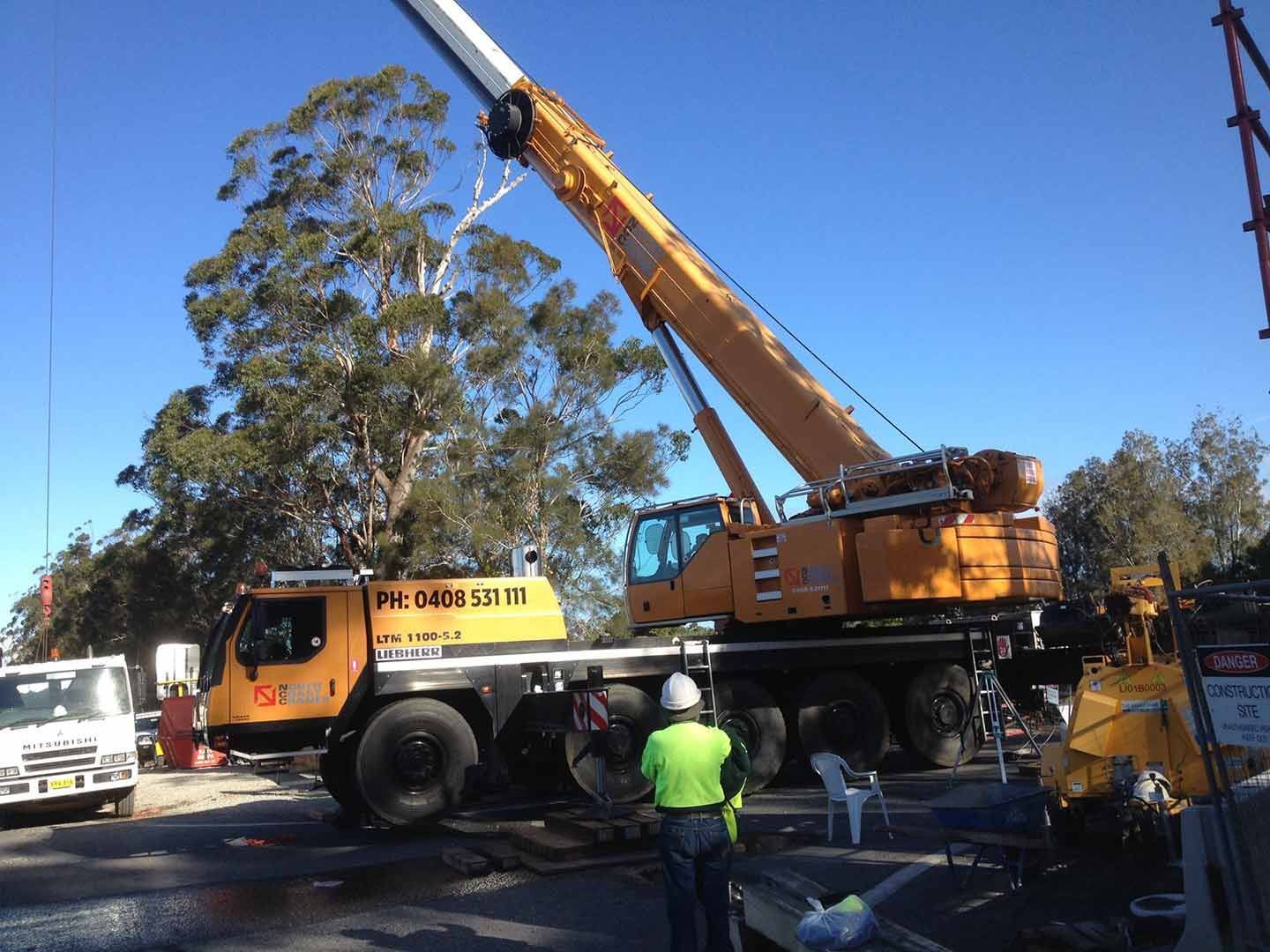 A Large Yellow Crane Is Being Used To Lift A Tree — North Coast Cranes In Bellingen, NSW
