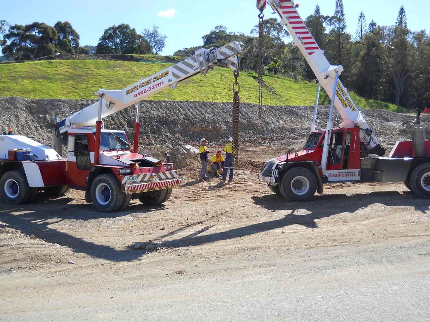 Two Trucks Are Parked Next To Each Other On A Dirt Road — North Coast Cane in Woolgoolga, NSW