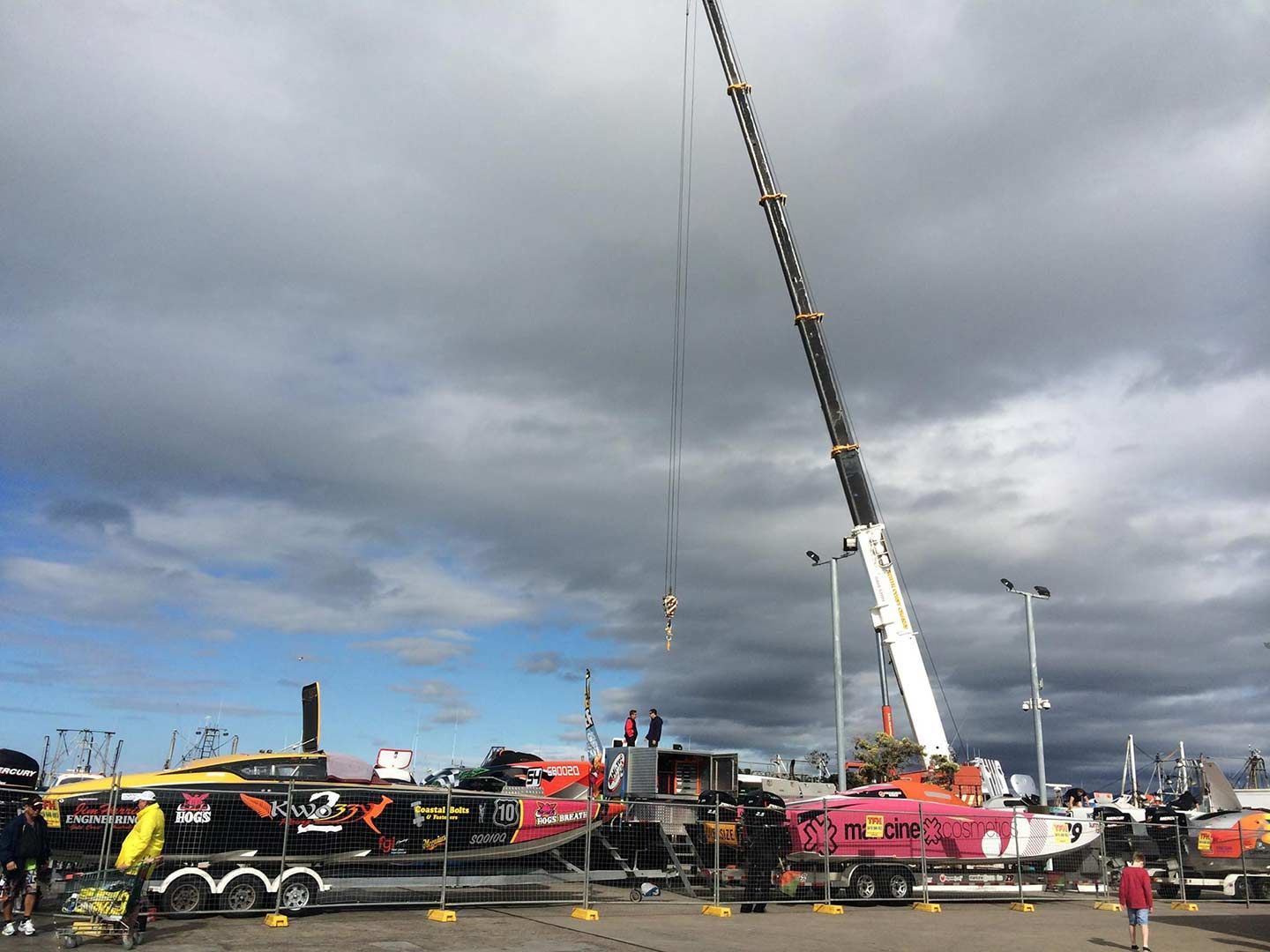 A Large Crane Is Lifting A Boat In A Parking Lot — North Coast Cranes In Grafton, NSW