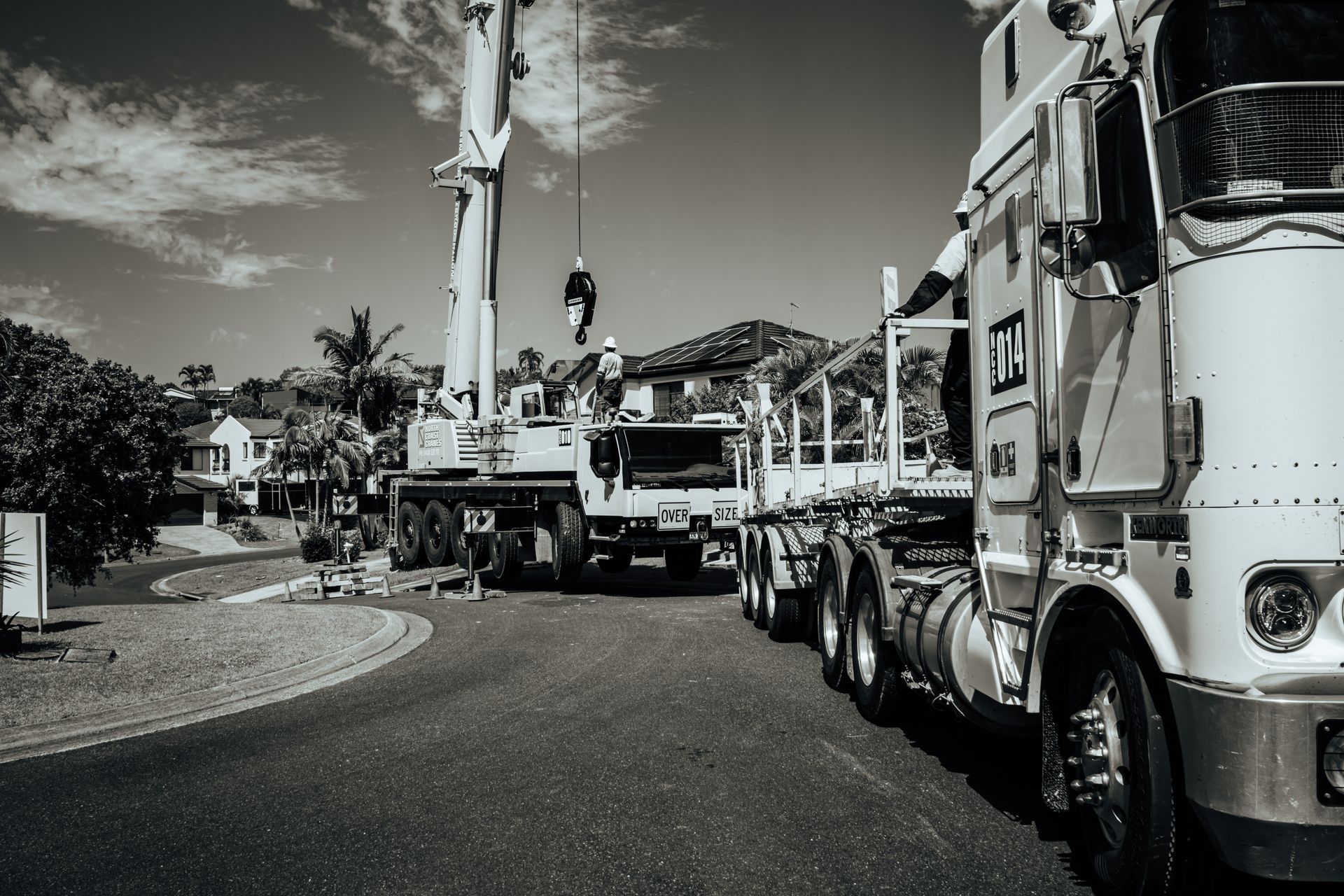 A Black And White Photo Of Two Trucks Parked On The Side Of A Road — North Coast Cranes In Coffs Harbour, NSW