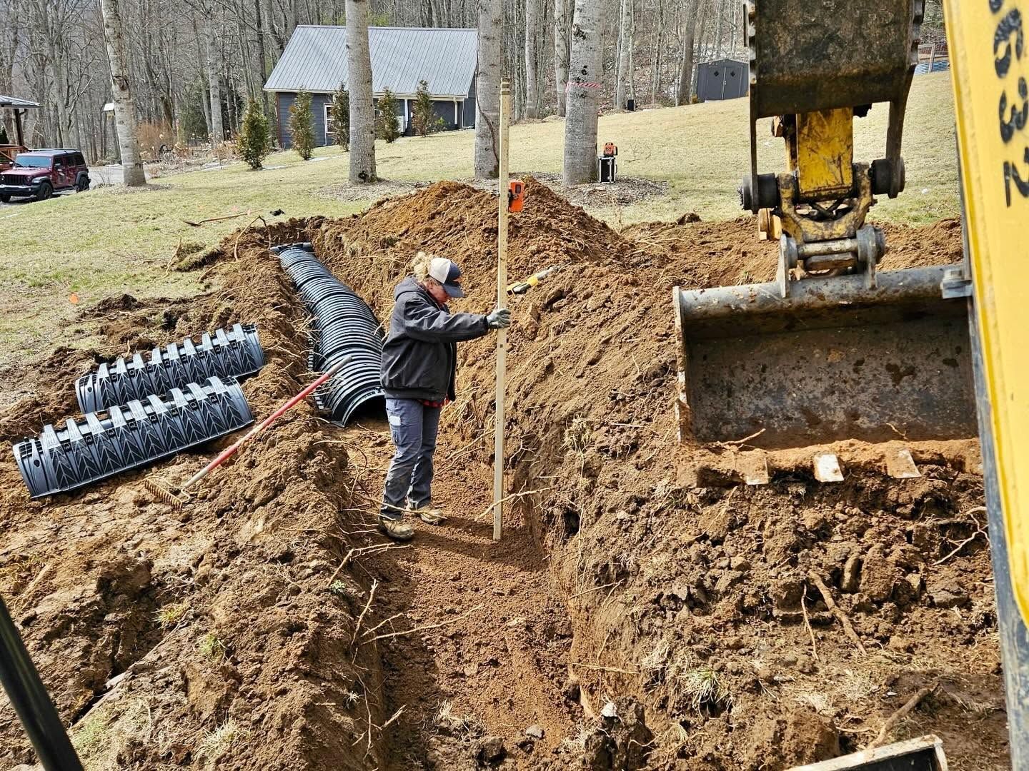 Child balancing on dirt pile beside excavator at a muddy construction site