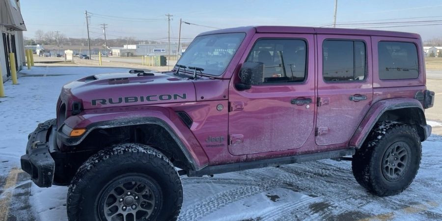 A pink Jeep Wrangler with automotive window tint parked in the snow in Fairfield, Ohio.