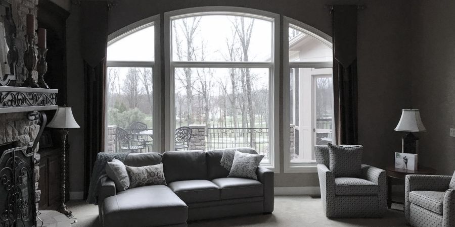 A cozy living room in Fairfield, Ohio, with residential window tint on the windows, featuring a couch, chairs, lamps, and a fireplace.
