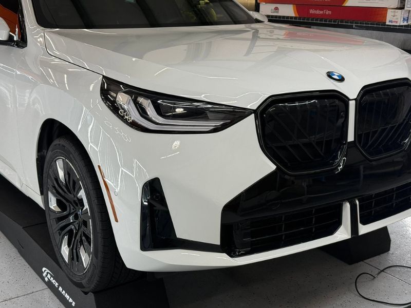 Front end of BMW x3 in process of paint protection film installation