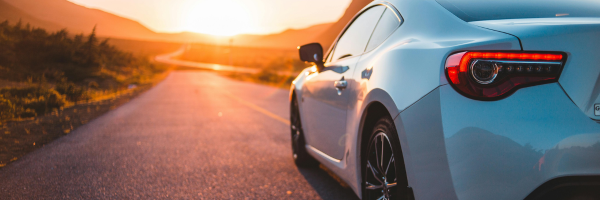 Vehicle on the road comparing paint protection film and ceramic coating benefits
